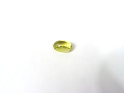 un gros plan d'une pierre précieuse jaune sur une surface blanche