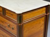 a close up of a marble top chest of drawers on a grey surface