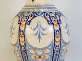 a blue and white vase sitting on a gold stand