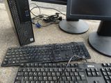 a computer keyboard and a monitor on the ground