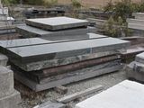 a pile of granite blocks on the ground in the yard