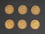 six gold sovereigns, one of which has a head and four of which have a crown on them