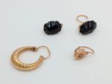 three pairs of gold and black earrings on a white surface