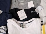 a lot of t - shirts that are sitting on a table