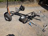 a small trailer with a wheel and some tools on the ground