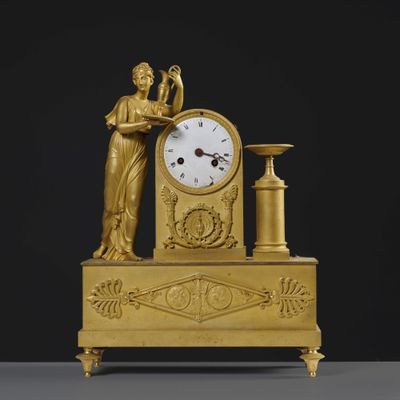 an image of a gold clock with a woman holding a vase