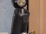 a coffee maker sitting on top of a table next to a laptop