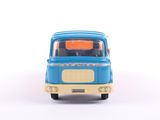 a blue toy truck with a yellow top on a white surface