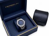 un gros plan sur une montre dans un coffret, à côté d'un portefeuille