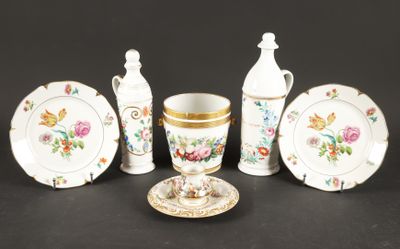 cinq pièces de vaisselle en porcelaine posées sur une table, accompagnées d'une tasse et d'une soucoupe