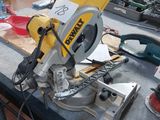 une scie circulaire jaune et noire posée sur une table dans un atelier