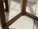 a wooden table with a glass top on a tiled floor