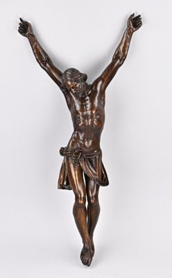 une statue en bronze représentant un homme sur une croix, les mains levées