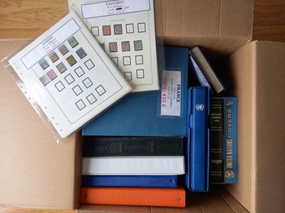 de nombreux livres dans une boîte en carton posée sur le sol