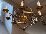 a chandelier that has a clock on it in a room