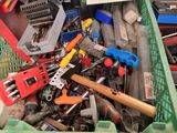 pile of assorted tools in a green bin on a wooden floor