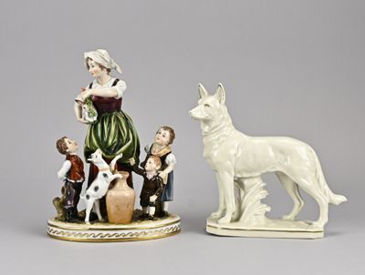 two figurines of people and a dog on a table