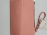 an image of a pink purse with a tag on it
