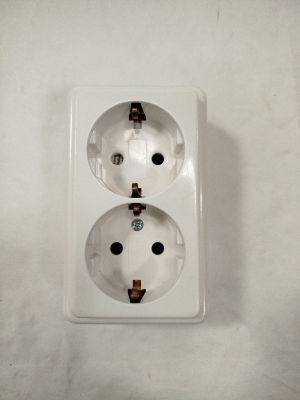 une prise électrique blanche sur laquelle figurent deux points noirs
