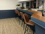 a picture of a restaurant with a bar and chairs