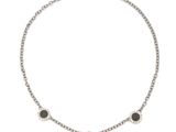 un collier noir et blanc composé de trois pierres noires montées sur une chaîne en argent