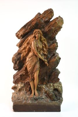 statue d'une femme debout sur un rocher avec un chien