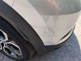 a close up of a car ' s tire with a dog in the background