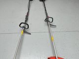 a couple of lawn mowers sitting on top of a garage floor
