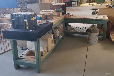 un grand établi au milieu d'une pièce, sur lequel sont posées de nombreuses boîtes