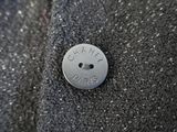 a button with a name on it sitting on a piece of fabric