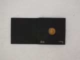 an open book with a gold coin on top of it