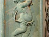 a statue of a cupid on the side of a building