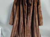 a brown fur coat hanging on a rack in a room
