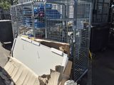 a pile of boxes and a metal fence on the side of the road