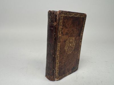 an old book sitting on top of a white surface