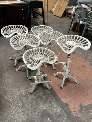 plusieurs chaises blanches empilées les unes sur les autres dans une pièce