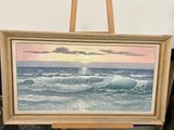 an oil painting of a sunset over the ocean on a easel