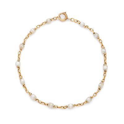 un bracelet en chaîne d'or orné de perles blanches sur fond blanc