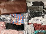 a bag of clothes and a purse sitting on a table