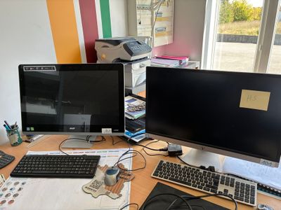 un bureau sur lequel sont posés deux écrans d'ordinateur et un clavier