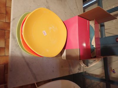 Des assiettes aux couleurs vives sont empilées les unes sur les autres sur une étagère