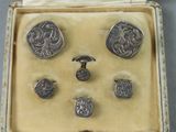 a box with a bunch of silver buttons in it