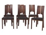 un lot de quatre chaises en bois avec des assises recouvertes de cuir noir
