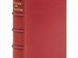 un livre rouge avec une reliure dorée sur la couverture