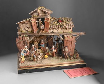 figurine représentant une crèche avec une mangeoire et une femme dans une étable