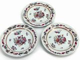 three plates with floral designs on them on a white surface
