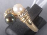 gold ring with pearls and diamonds on display on black surface