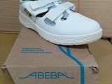 une image représentant une paire de chaussures blanches posée sur une boîte