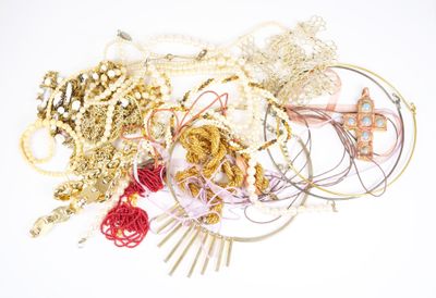 un tas de colliers et de bracelets de toutes sortes posés sur une surface blanche