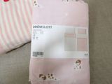 two sheets of pink and white bedding with a dog on them